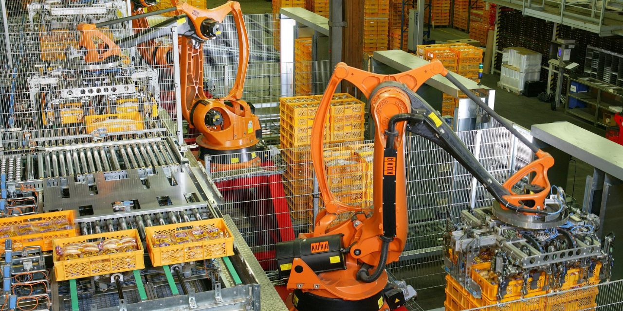 Robôs industriais laranja em uma linha de paletização de fábrica